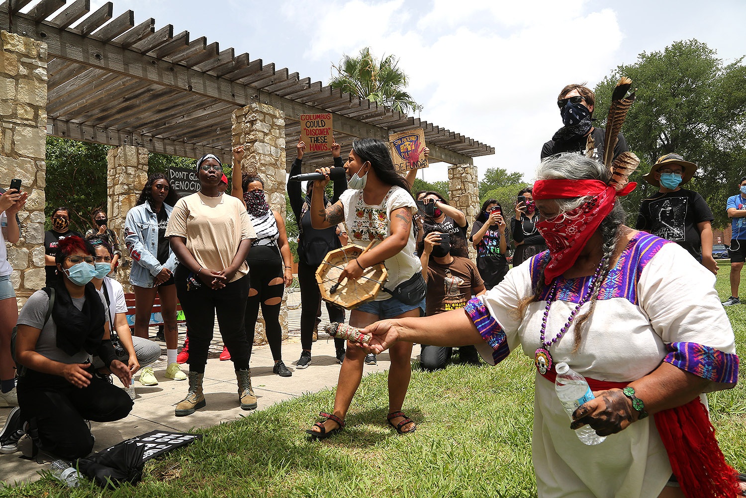 Ceiba (center) speaks to a group of roughly 50 advocates for the removal of the Christopher Columbus statue as Diana Uriegas (right) offers a sage cleanse during a protest Saturday, June 27, 2020, at Columbus Park, 200 Columbus St. Photo by Ben Olivo | Heron