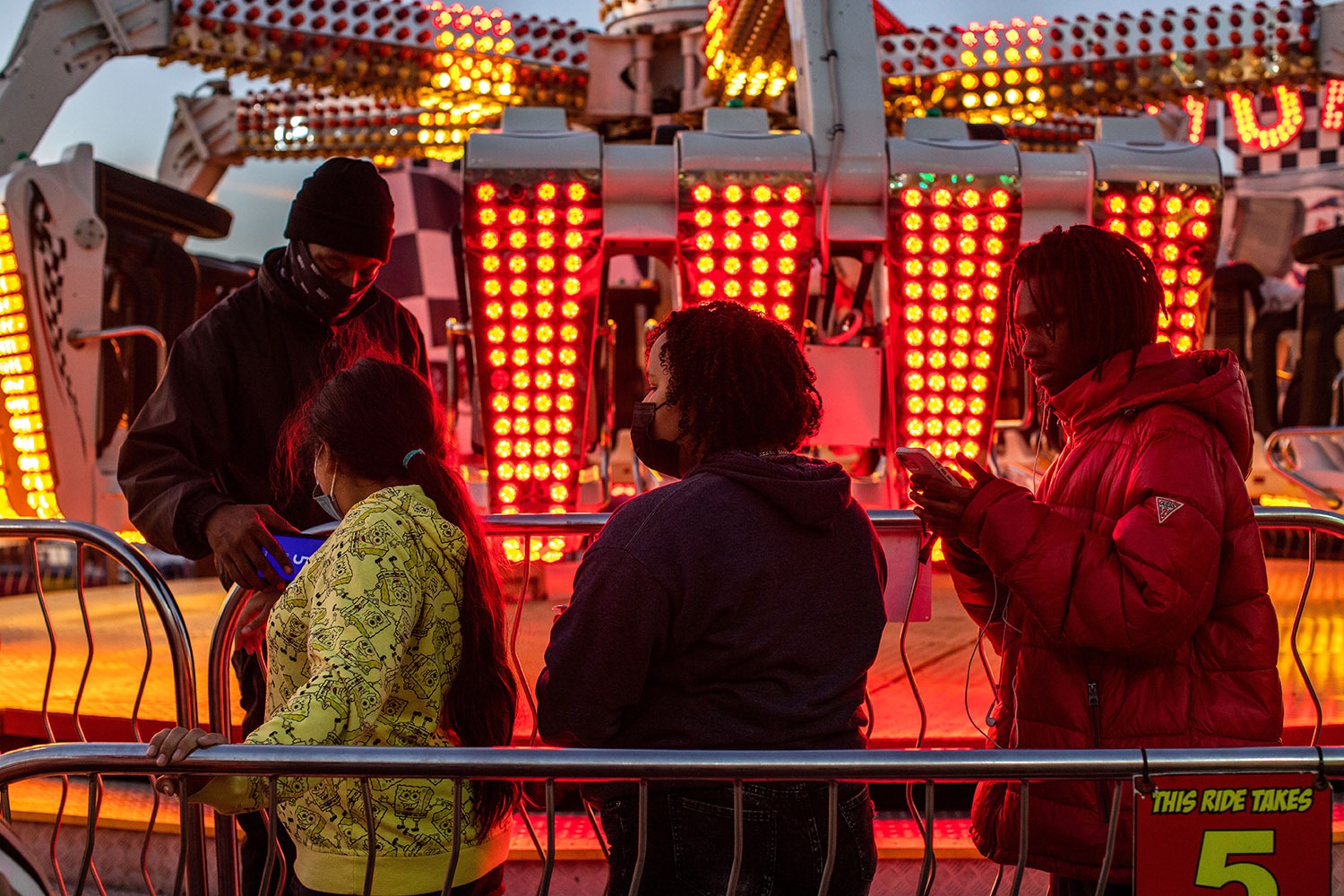 People wait in line for a fair ride at the San Antonio Stock Show and Rodeo carnival on Friday, Feb. 18, 2022. Photo by Kaylee Greenlee Beal | Heron contributor
