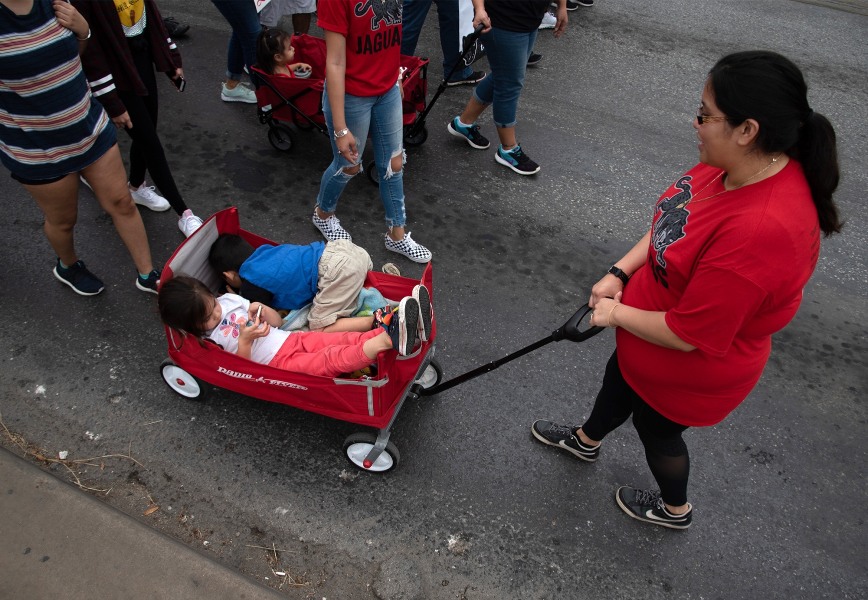 Amanda Denman pulls her kids Destiny, 4, and Damien, 3, in a Radio Flyer during San Antonio’s 23rd annual César E. Chávez March for Justice on Saturday, March 30, on Guadalupe Street. Photo by V. Finster | Heron