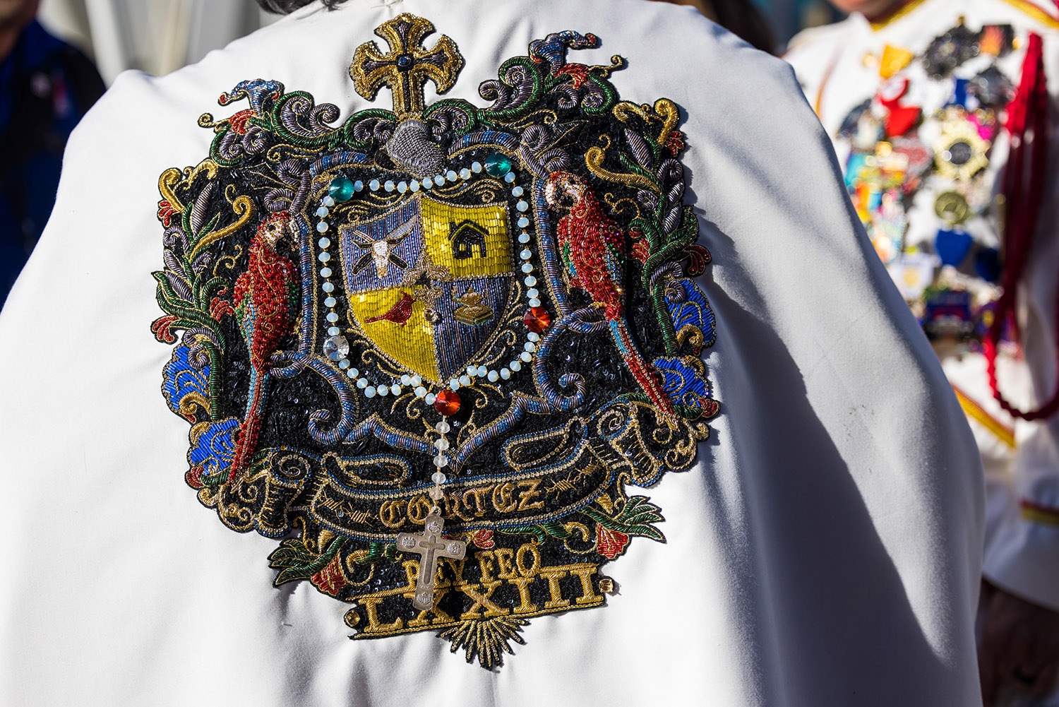 Intricate patchwork detailing Rey Feo LXXIII Augustine Cortez, Jr.’s cape can be seen during Fiesta Fiesta at Hemisfair, San Antonio, TX, on Thursday, March 31, 2022. Photo by Chris Stokes | Heron contributor