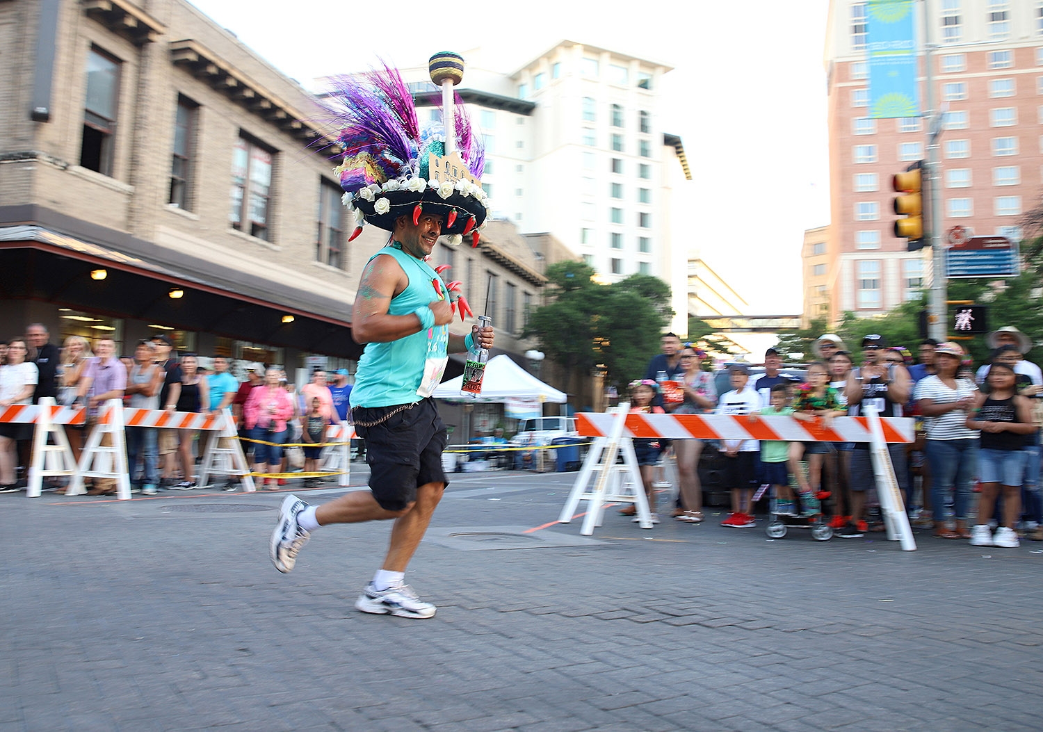 A runner smiles at parade-watchers during the Fiesta Fandango Run on Saturday. The 2.6 mile run preceded to the Flambeau Parade. <em>Photo by Brianna Rodrigue | Heron contributor</em>