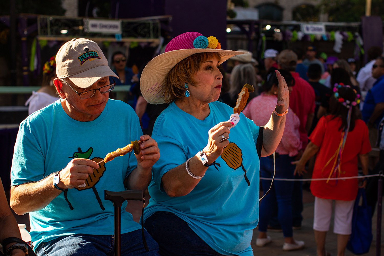 Daniel and Elizabeth Ruiz enjoy a chicken-on-a-stick during the second night of A Night in Old San Antonio, or NIOSA, during Fiesta on Wednesday, April 6, 2022, at La Villita in downtown San Antonio, Texas. Photo by Kaylee Greenlee Beal | Heron contributor