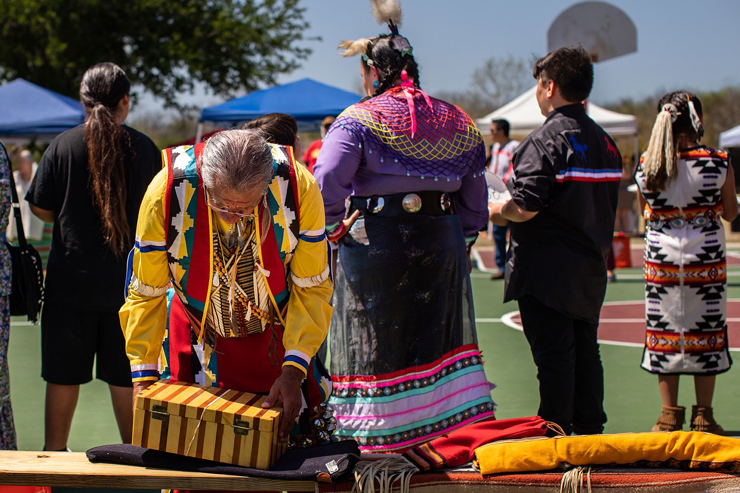 Marcus Cheko packs up his belongings at a Native American Fiesta Pow Wow including various feathers and blankets at Mission County Park #2, San Antonio, Texas. Photo by Kaylee Greenlee Beal | Heron contributor