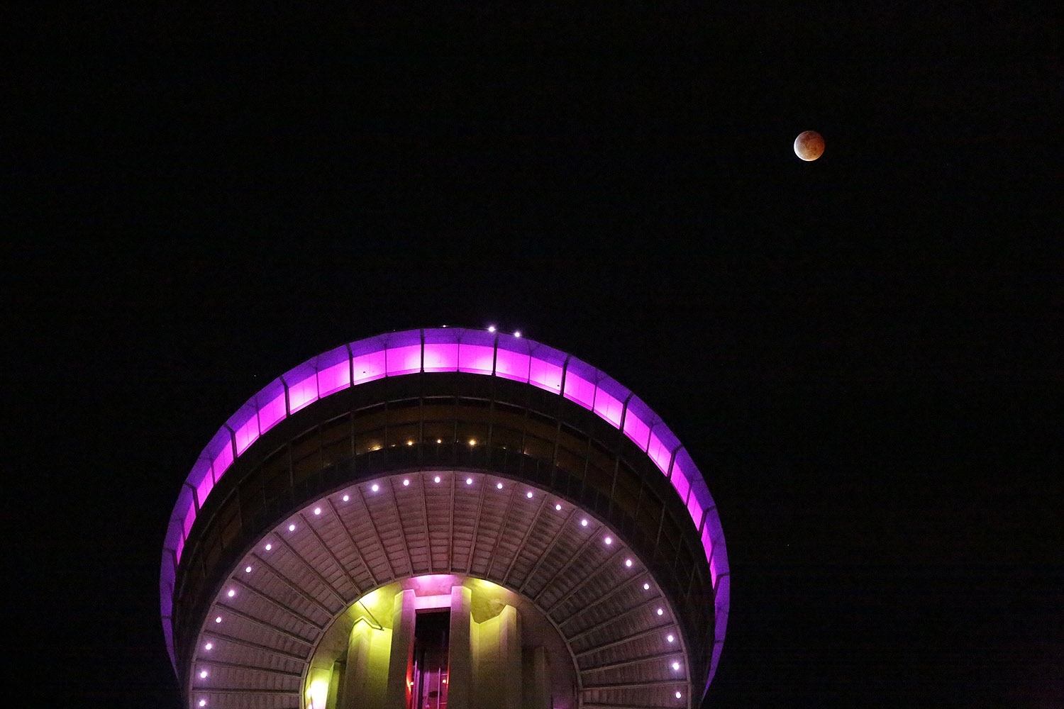 The super blood wolf moon hovers above the Tower of the Americas late Sunday night. Photo by Ben Olivo | Heron