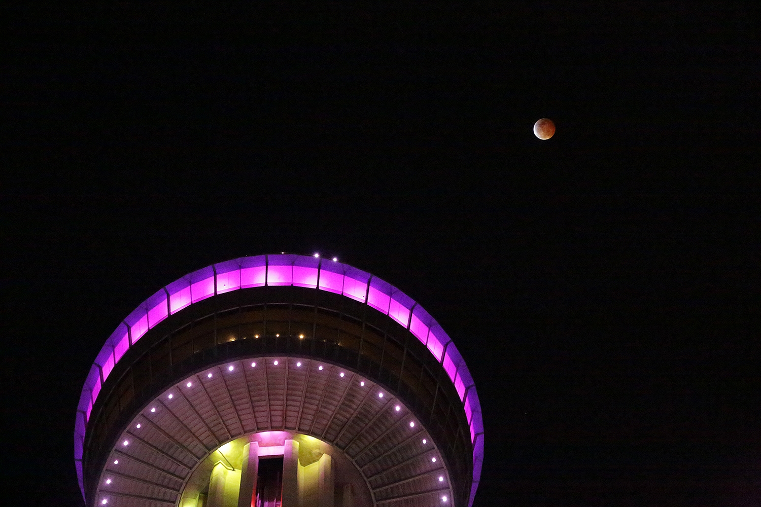 The super blood wolf moon hovers above the Tower of the Americas late Sunday night. Photo by Ben Olivo | Heron