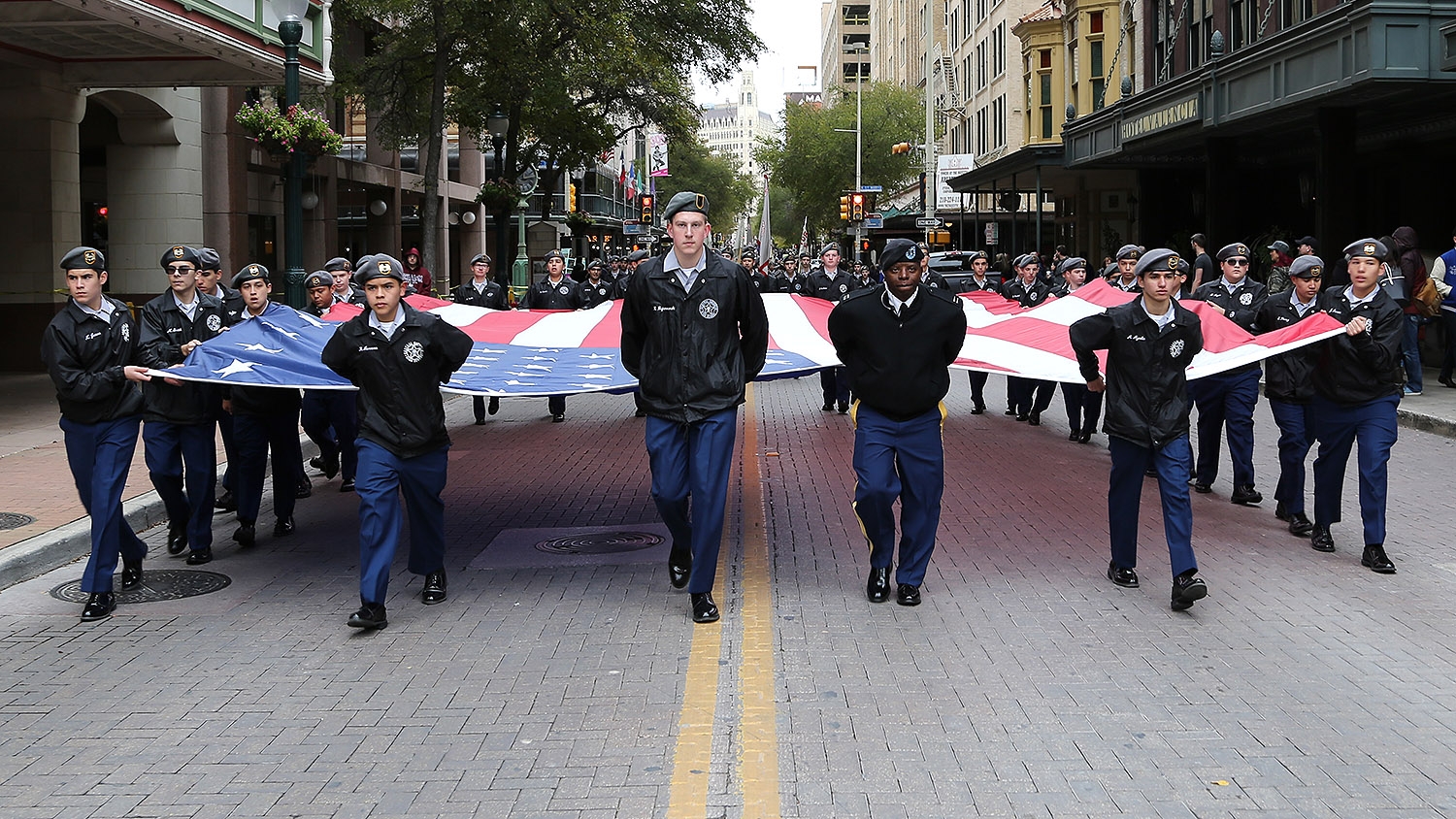 Members of the Central Catholic High School JROTC carry the Stars & Stripes down Houston Street. <em><b>Photo by Ben Olivo | Heron</b></em>