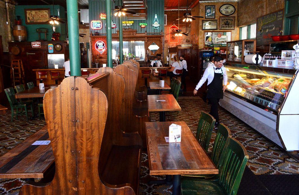 Two people sitting at each end of the bar at Schilo’s Sept. 24, 2020. This restaurant offers dine-in, takeout and no-contact delivery. Photo by Victoria Martinez