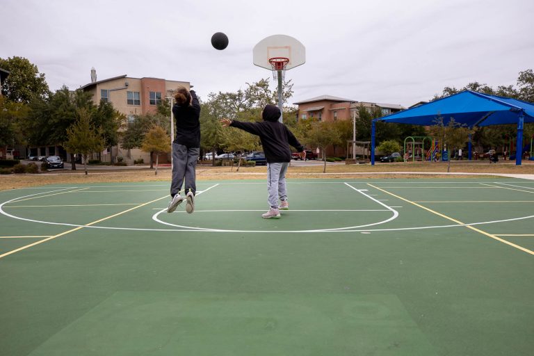 Kids play basketball at the Labor Street Park in October 2020.