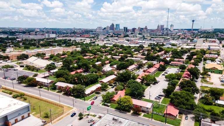 Drone shot taken July 30, 2021, shows the Alazan Courts in the foreground and the downtown San Antonio skyline in the background.