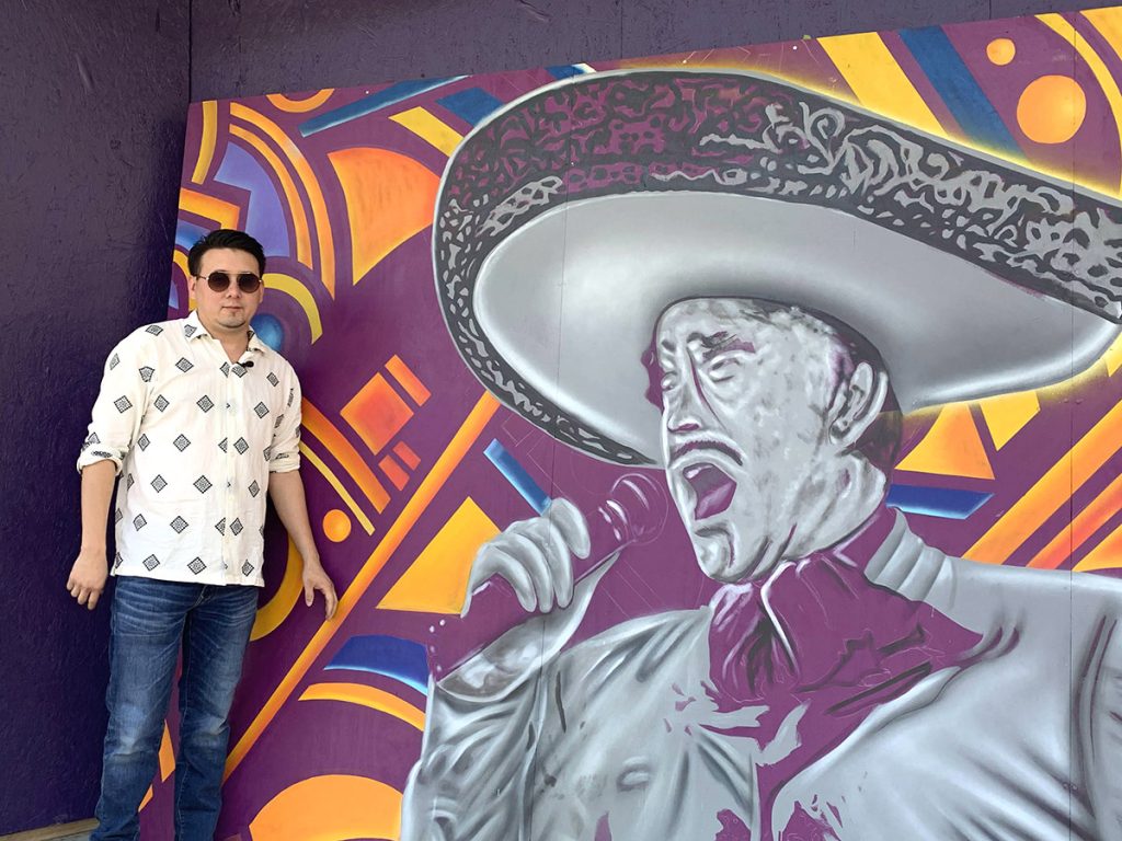 Local artist Alan Calvo stands next to a mural he painted of legendary singer Vicente Fernandez placed outside the Alameda Theater, 318 W. Houston St. where it will permanently stand once the renovation is completed.